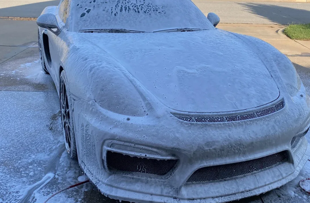 A car covered in wash foam during a hand wash