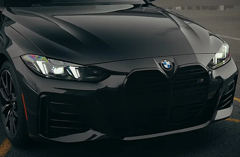 The front end of a black car finished to a high gloss