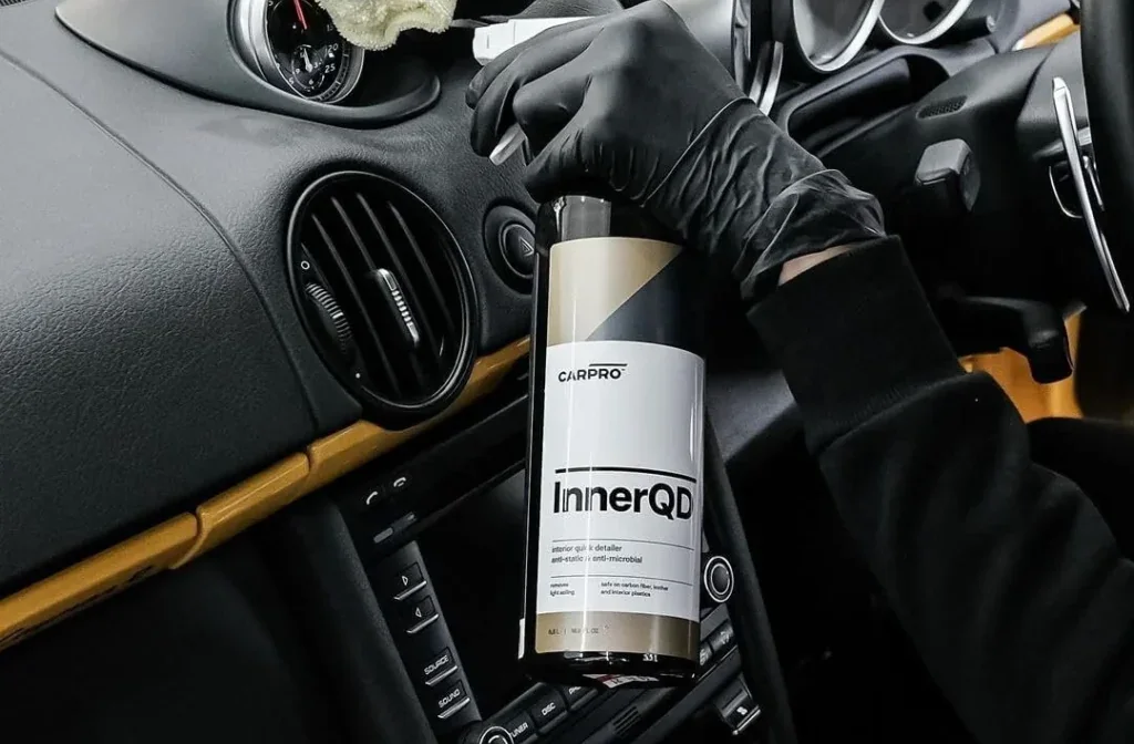 Interior detailing spray being applied to a car dashboard